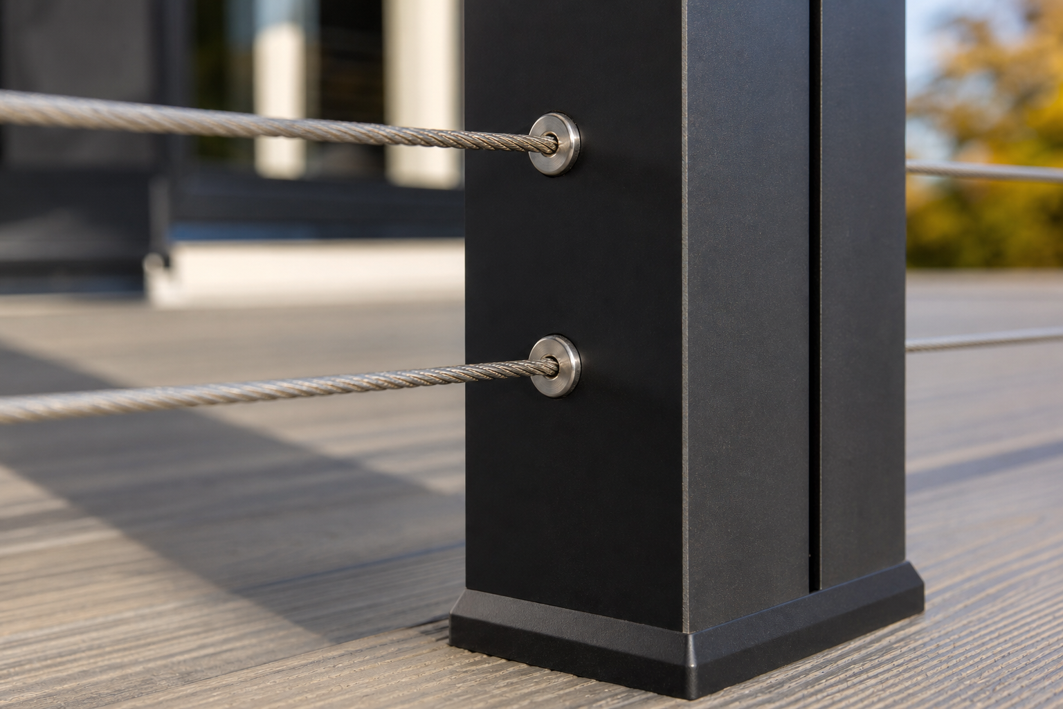 Black deck post with stainless steel cable railing fittings on composite decking — representative design concept